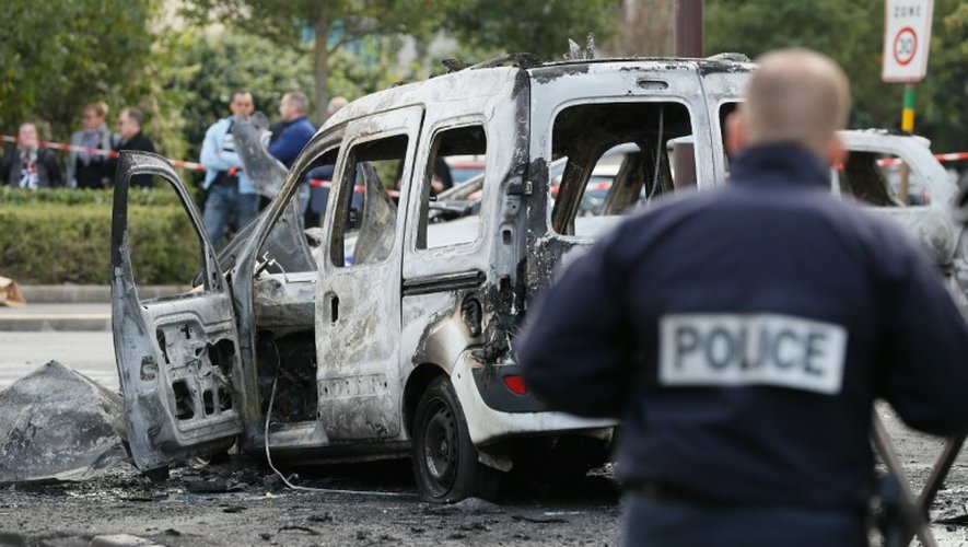 Un policier devant la carcasse d'un véhicule de police incendié à  Viry-Chatillon le 8 octobre 2016