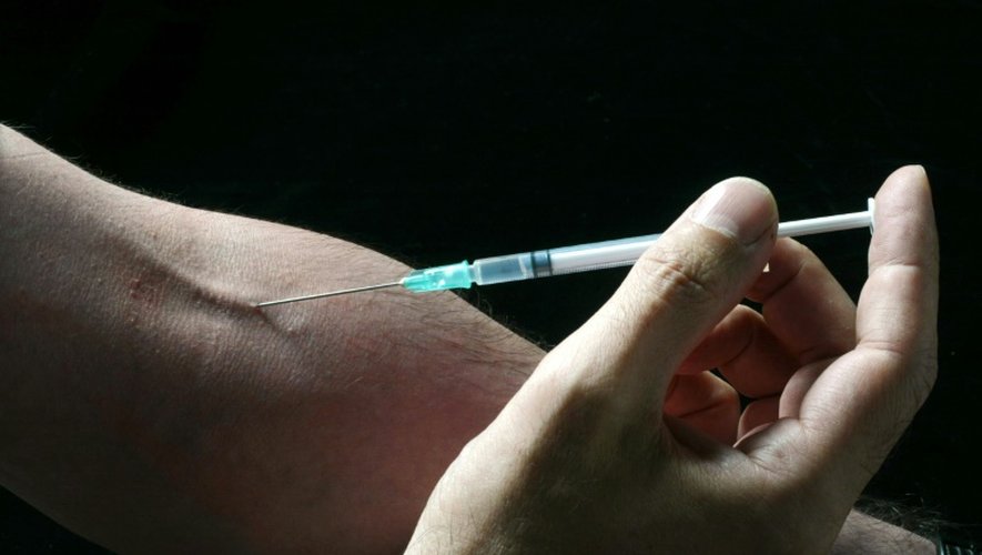 Un homme se pique une veine avec une seringue, le 11 août 2003 à Paris