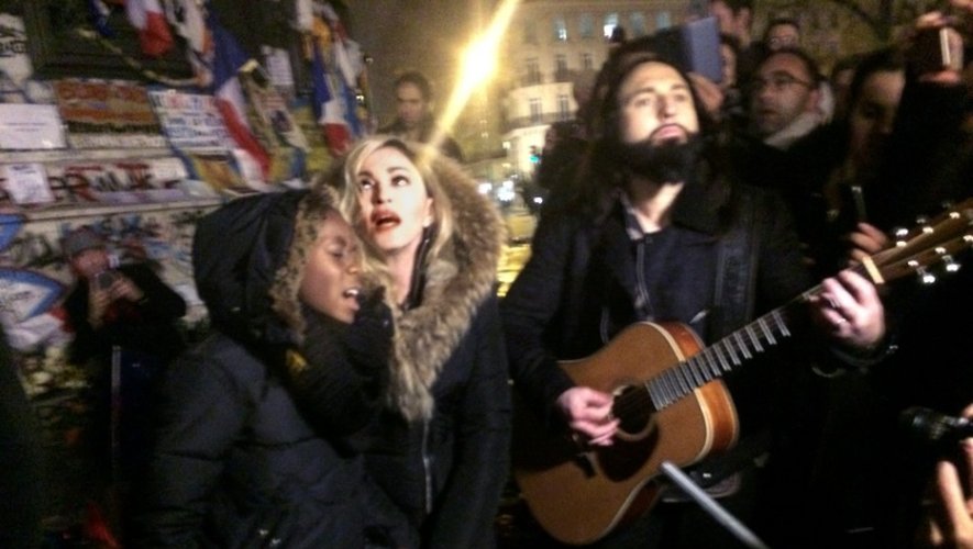 Madonna, entourée de son fils David Banda (à gauche) et de son guitariste Monte Pittman (à droite), chante sur la place de la République le 10 décembre 2015 en hommage aux victimes du 13 novembre