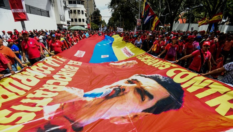 Des partisans de Nicolas Maduro portent une banderole géante à l'effigie du président vénézuélien lors d'une manifestation, le 18 octobre 2016 à Caracas