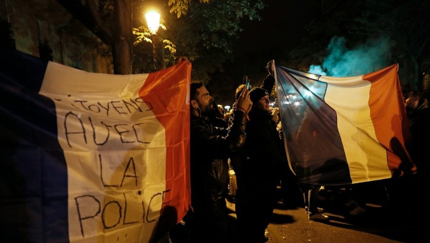 Un drapeau français marqué "Citoyens avec la police" pendant un rassemblement de policiers devant Notre-Dame de Paris le 21 octobre 2016 pour protester contre les violences dont ils font l'objet