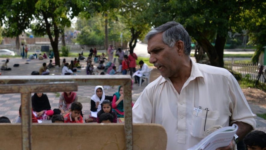 Après sa journée de pompier-secouriste, Muhammad Ayub fait la classe à des enfants d'un bidonville, le 30 août 2016, dans un parc réputé d'Islamabad