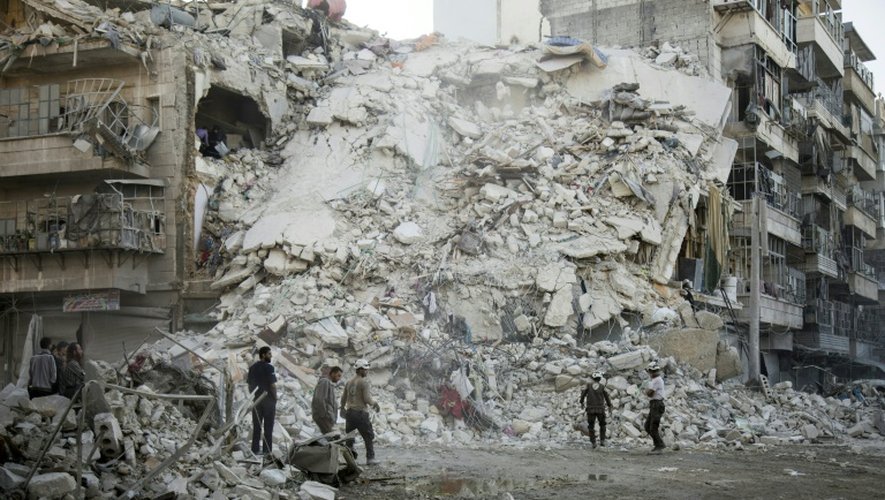 Des Casques blancs syriens recherchent des victimes dans les décombres d'immeubles touchés par des bombardements dans un quartier rebelle d'Alep, le 17 octobre 2016