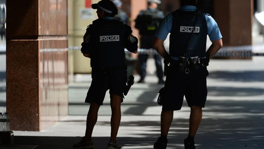 Des policiers armés devant le café où sont retenus des otages à Sydney, le 15 décembre 2014