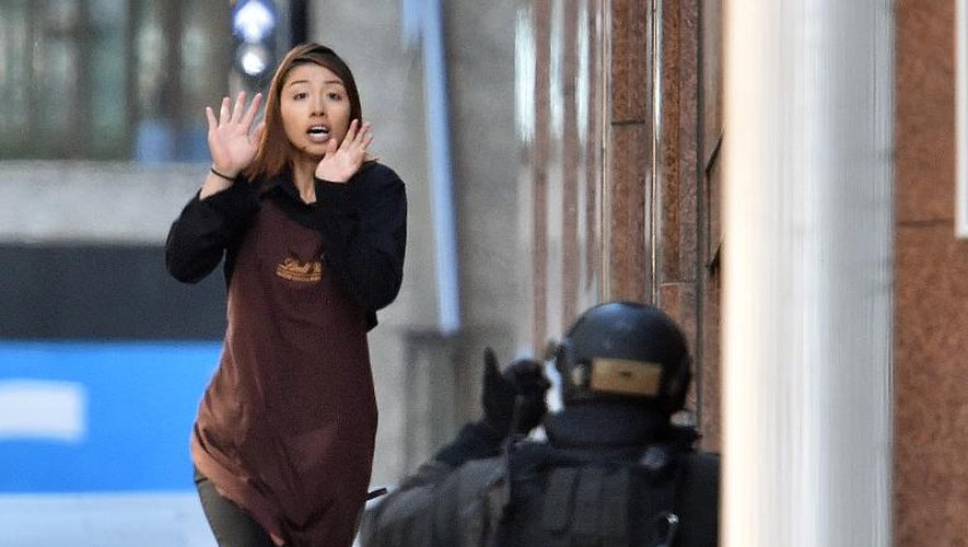 Une des otages sortant d'un café dans le centre Sydney le 15 décembre 2014