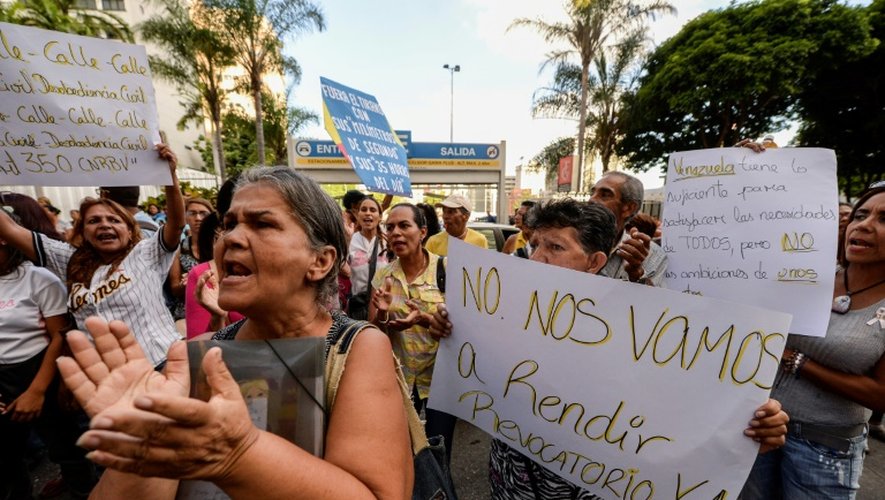 Des manifestants brandissent des pancartes demandant un référendum contre le président Nicolas Maduro, le 21 octobre 2016 à Caracas