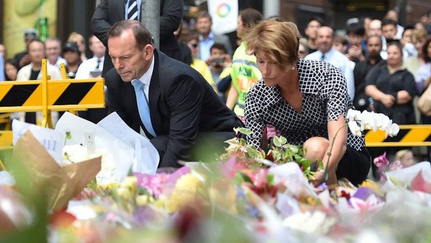 Le Premier ministre australien Tony Abbott et sa femme Margaret déposent des fleurs sur le lieu de la prise d'otages le 16 décembre 2014 à Sydney