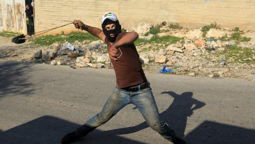 Un militant palestinien s'en prend aux forces de sécurité israéliennes, le 11 décembre 2015 dans le village de Kafr Qaddum, près de Naplouse, en Cisjordanie occupée