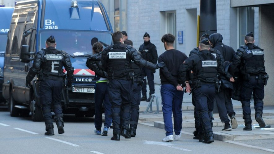 Les gendarmes arrêtent des proches des accusés devant le tribunal de Grenoble, le 12 décembre 2015