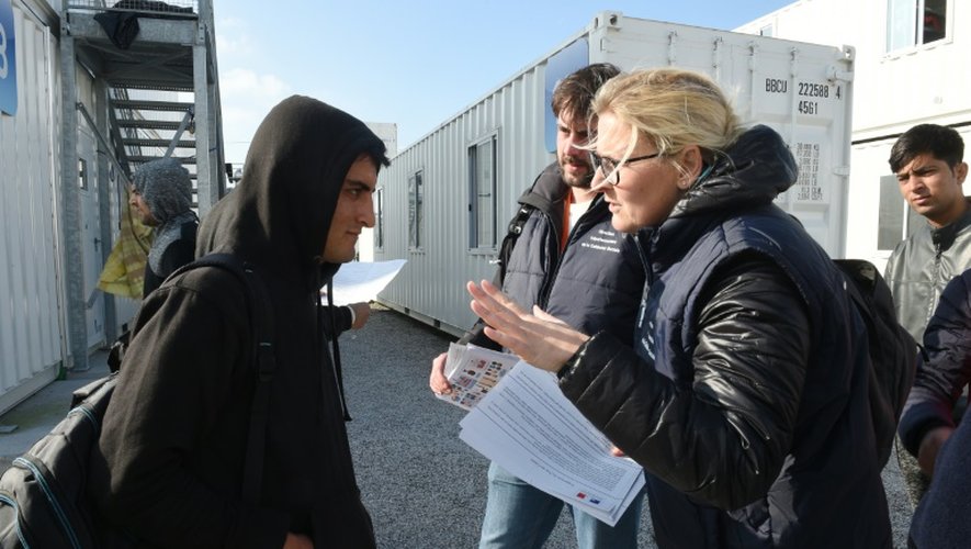 Des membres de la Direction départementale de la cohésion sociale distribuent des informations aux migrants sur le démantèlement de la "Jungle" de Calais, le 23 octobre 2016