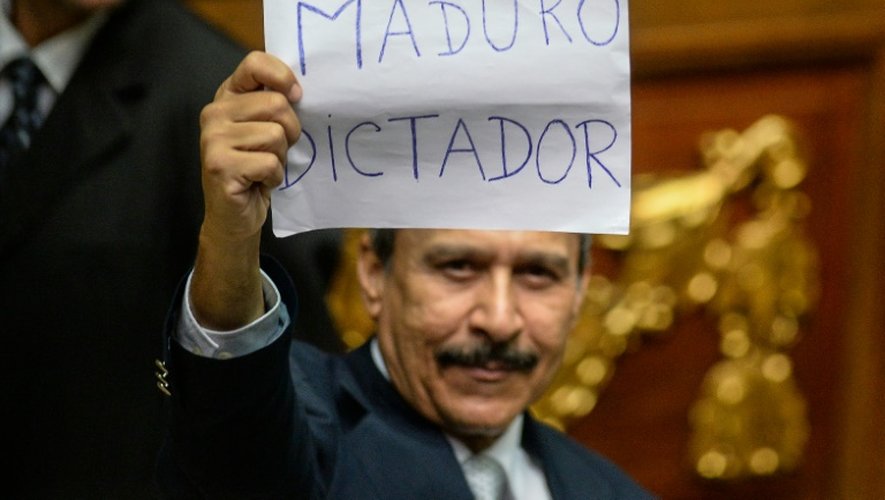 Un député d'opposition tient une pancarte portant l'inscription "Maduro dictateur", le 23 octobre 2016 dans l'enceinte du Parlement