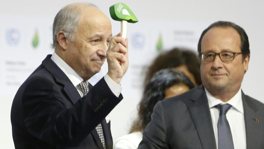Le ministre des Affaires étrangères français, Laurent Fabius (g) brandit son petit marteau vert, sous le regard du président François Hollande, à Paris le 12 décembre 2015