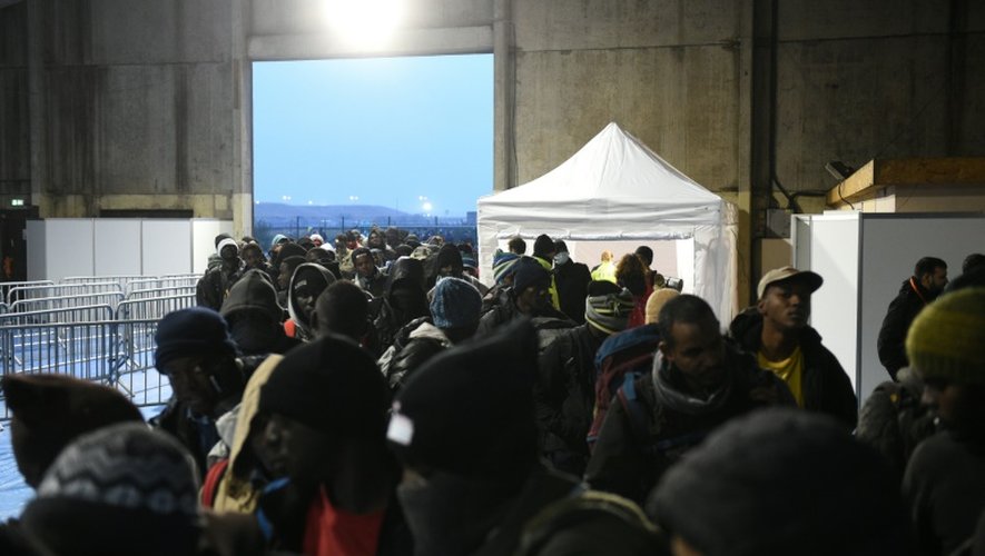 Des migrants rassemblés devant le centre de transit, un grand hangar désaffecté, le 2 octobre 2016 à Calais
