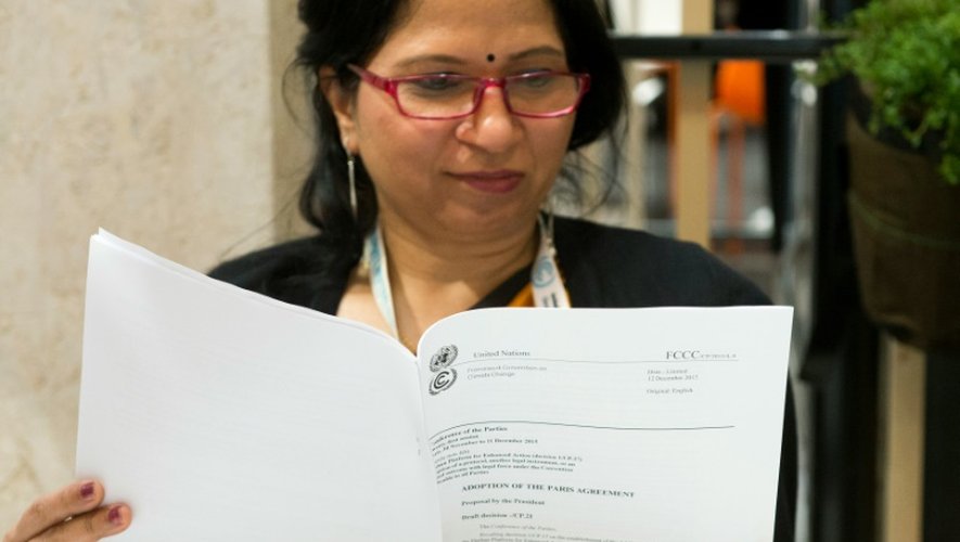 Une femme regarde une copie de l'accord sur le climat conclu à l'issue de la COP21 au Bourget le 12 décembre 2015