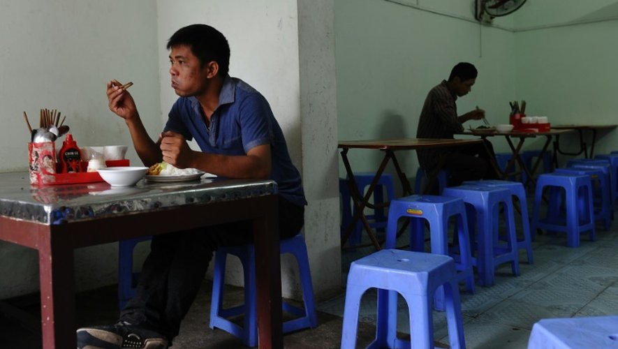 Deux ouvriers venus de la campagne prennent leur déjeuner à Hanoï le 21 septembre 2015 dans un restaurant tenu par d'autres migrants économiques Le Van Mung et Ngoc Anh