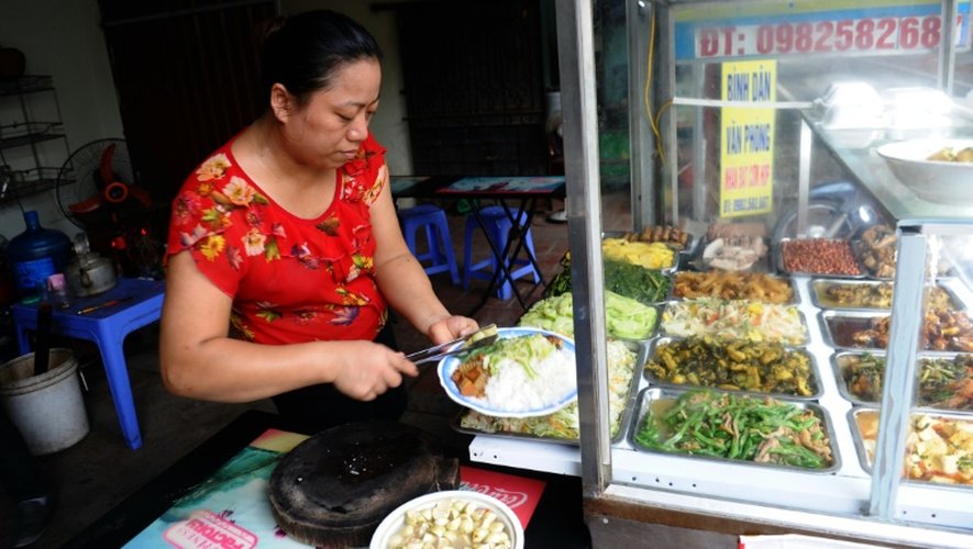 Ngoc Anh, la femme de Le Van Mung, un couple venu de la campagne, vend des plats dans son petit restaurant à Hanoï, le 21 septembre 2015