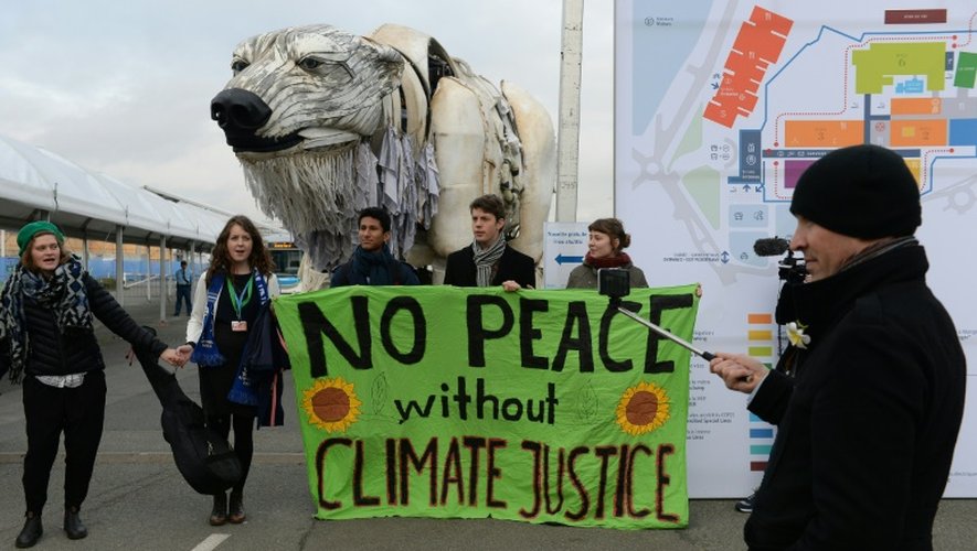 Des militants d'ONG déploient une banderole réclamant la justice climatique au Bourget, le 11 décembre 2015