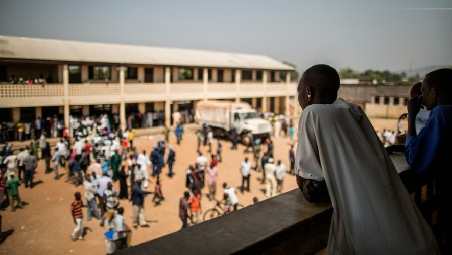 Un homme regarde le bureau de vote de Baya Dombia avant qu'il ne soit visé par des coups de feu, à Bangui le 13 décembre 2015
