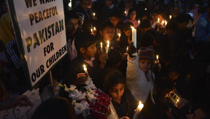 Des citoyens et des enfants pakistanais participent à une veillée le 18 décembre 2014 à Lahore, en souvenir des écoliers massacrés par des talibans à Peshawar