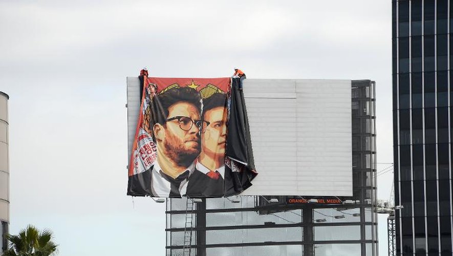 Des ouvriers enlèvent une affiche du film "L'interview" à Hollywood le 18 décembre 2014
