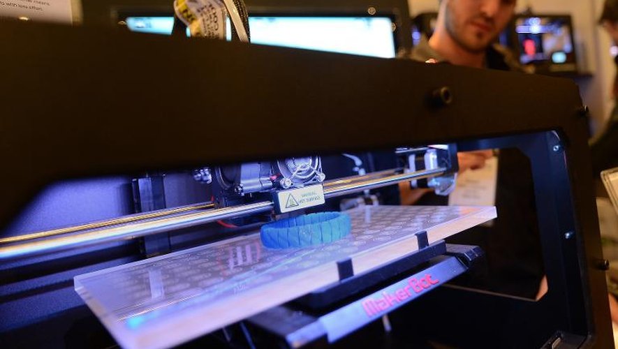 Des visiteurs observent une imprimante 3D en action durant une exposition à New York, le 22 avril 2013