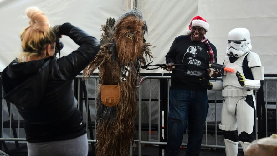 Un fan de Star Wars pose aux côtés des personnages Chewbacca (g) et un Stormtrooper (d) à la première de Star Wars, le 14 décembre 2015 à Hollywood
