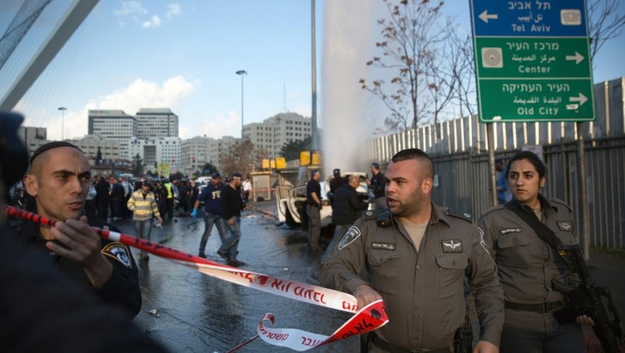 Des policiers israéliens sécurisent le périmètre autour de la voiture bélier qui a attaqué un arrêt de bus à Jérusalem le 14 décembre 2015