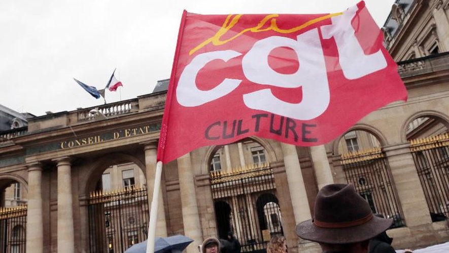 Des manifestants munis d'un drapeau de la CGT devant le Conseil d'Etat à Paris le 19 décembre 2014 veulent défendre une politique culturelle ambitieuse