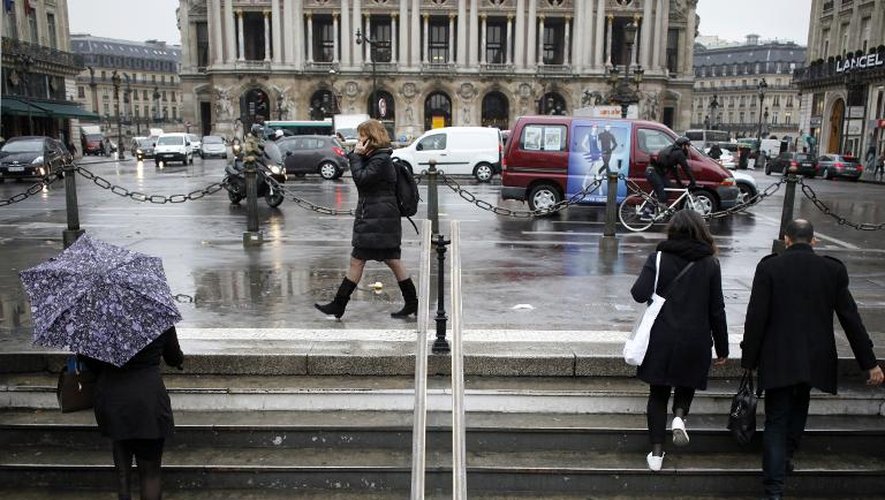 Des passants vêtus de noir place de l'Opéra à Paris le 10 décembre 2014