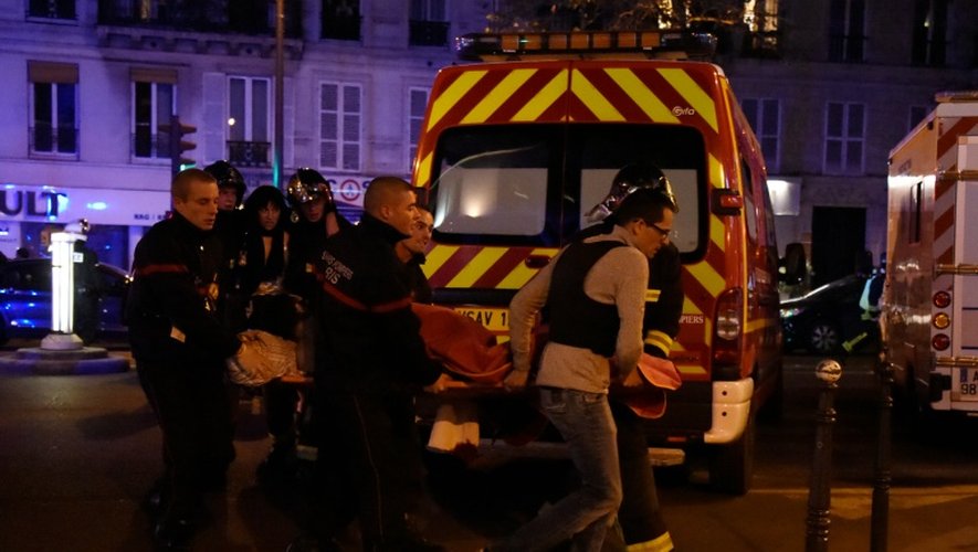Des secouristes évacuent des victimes des attentats près du Bataclan à paris le 13 novembre 2015