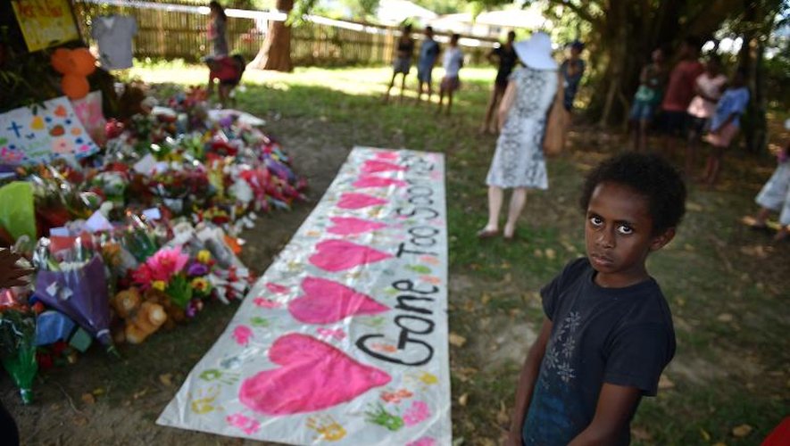 Des habitants de Cairns, dans le nord de l'Australie, viennent se recueillir près de la propriété où huit enfants ont été tués, le 20 décembre 2014