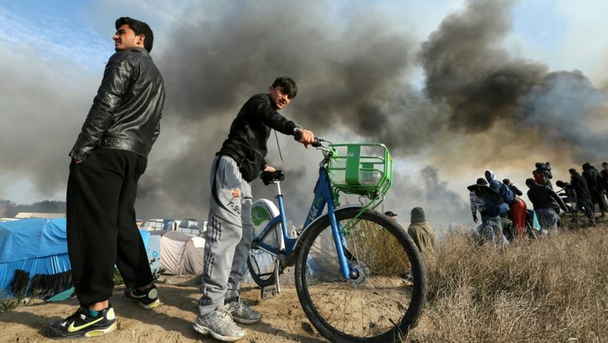 Un migrant et son vélo dans la "Jungle" de Calais en feu, le 26 octobre 2016.