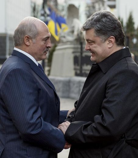 Poignée de mains entre le président bélarusse Alexandre Loukachenko (g) et son homologue ukrainien Petro Porochenko à Kiev le 21 décembre 2014