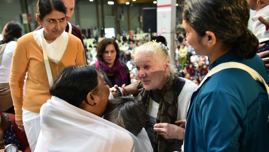 Une femme vient d'être étreinte par la gourou indienne Mata Amritanandamayi (g), connue sous le nom de "Amma", lors d'un rassemblement à Paris, le 26 octobre 2016