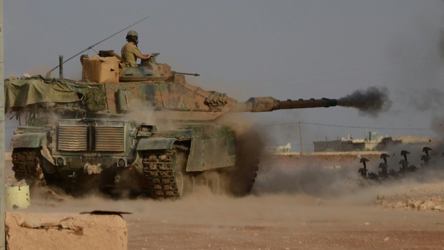 Des soldats turcs à bord d'un char tirent sur une position du groupe Etat islamique près de Beraan, au nord de d'Alep, le 24 octobre 2016 en Syrie