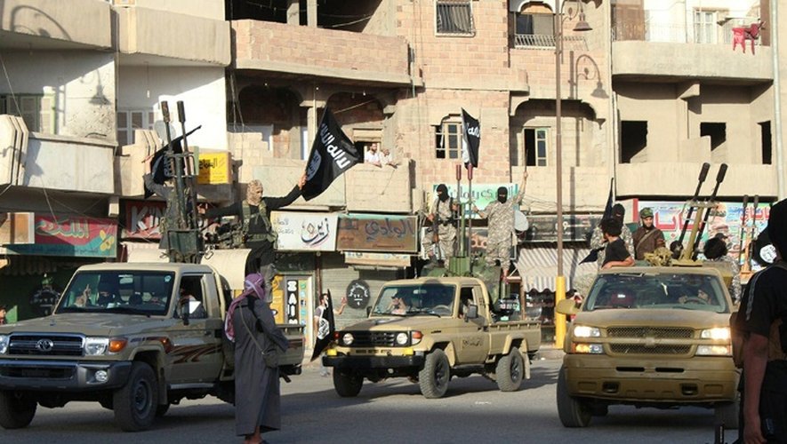 Photo diffusée sur le site jihadiste Welayat Raja, le 30 juin 2014, montant des jihadistes du groupe Etat islamique paradant dans une rue de Raqa, en Syrie