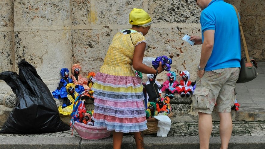 Un touriste achète un souvenir à une cubaine dans le quartier historique de La Havane, le 16 décembre 2015