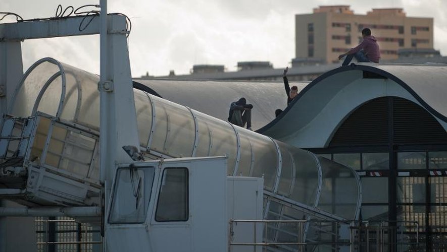 Des jeunes marocains attendent sur le toit du port de Ceuta de sauter dans un bateau pour gagner le continent européen, le 5 décembre 2014