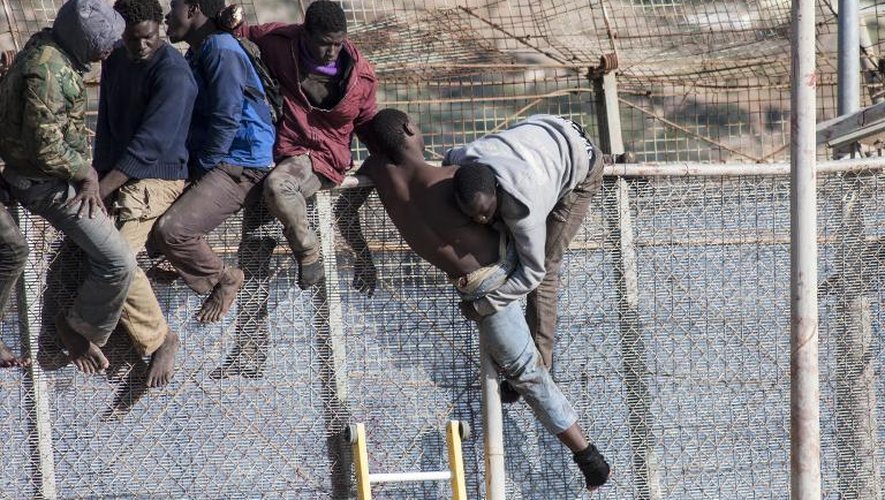 Des migrants escaladent les grillages qui séparent le frontière entre l'enclave espagnole de Melilla et le Maroc le 3 avril 2014