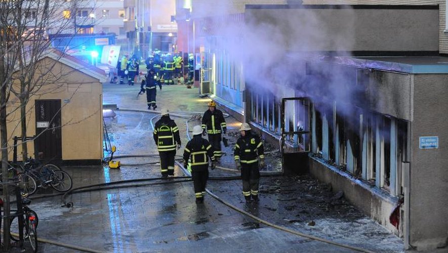 Des pompiers sur le site d'un incendie causé par un engin jeté de l'extérieur dans une mosquée du centre de la Suède, le 25 décembre 2014 à Eskilstuna