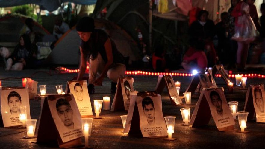 Une jeune femme allume des bougies lors d'une veillée à la mémoire des 43 étudiants mexicains disparus sur la place centrate de Chilpancingo, dans l'Etat de Guerrero, le 25 décembre 2014