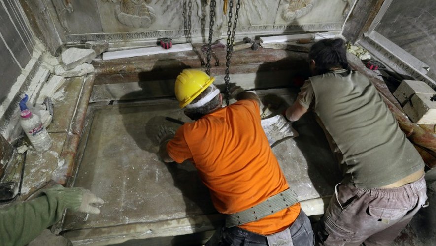 Des scientifiques replacent la plaque de marbre recouvrant la tombe que les chrétiens considèrent comme celle de Jésus dans l'église du Saint Sépulcre à Jérusalem, le 28 octobre 2016