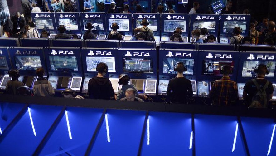 Des visiteurs du salon des jeux en ligne à Paris testent la PlayStation 4 le 29 octobre 2014