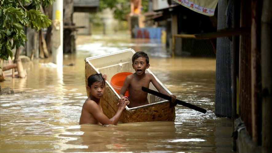 Des enfants dans une rue inondée le 18 décembre 2015 à Candaba aux Philippines
