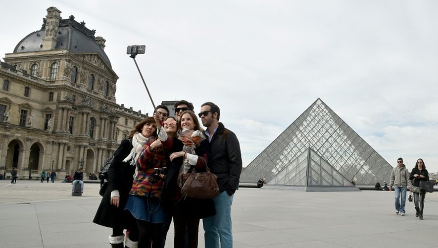 Des touristes devant le Louvre le 7 mars 2015 à Paris