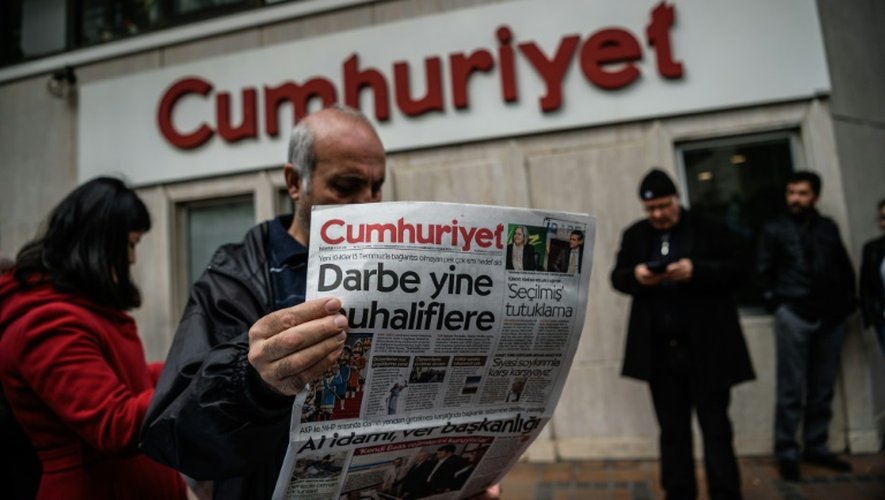 Un homme plongé dans la lecture de devant les locaux du quotidien le 21 octobre 2016 à Istanbul