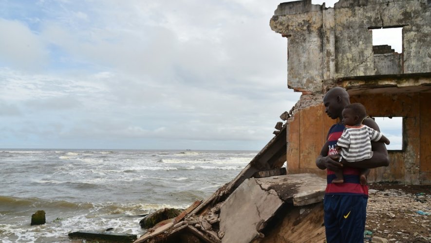 Un homme devant les ruines de la sous-préfecture  sur le rivage de de la lagune de Grand-Lahou, le 15 octobre 2015 en Côte d'Ivoire