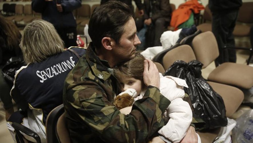 Un père et sa fille à leur arrivée à l'aéroport de Elefsina, à l'ouest d'Athènes, le 29 décembre 2014, rescapés de l'incendie du ferry Norman Atlantic