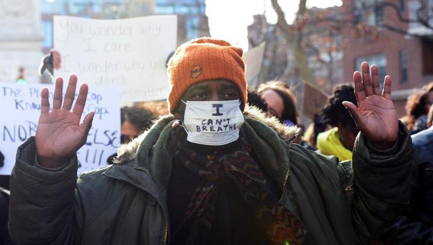 Un homme marche à New York le 13 décembre 2014 lors d'une manifestation dénonçant les violences policières contre les Noirs