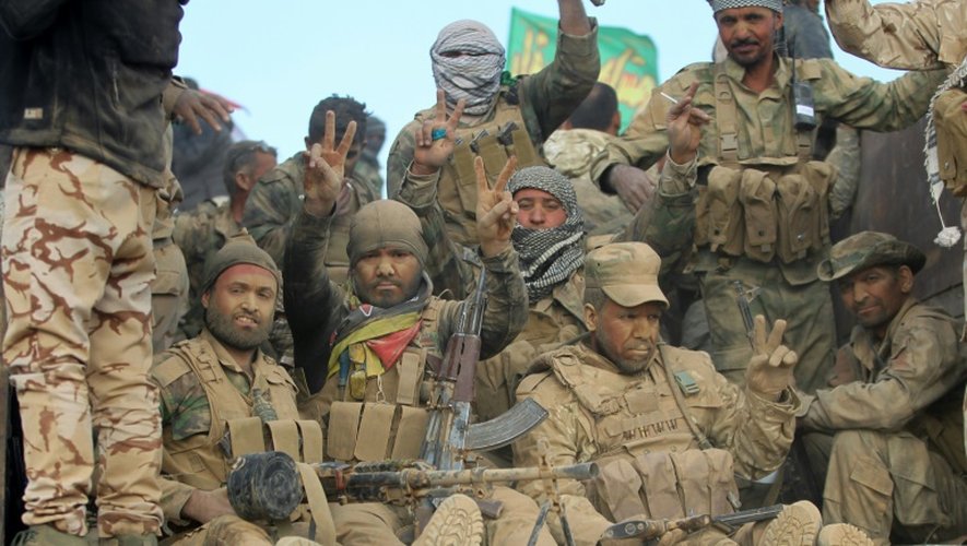 Des combattants chiites de la coalition Hachd  al-Chaabi font le signe de la victoire à l'arrivée dans un village au sud de Mossoul, le 31 octobre 2016
